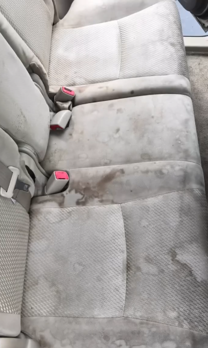 Stained dirty rear car bench seat before mobile detailing